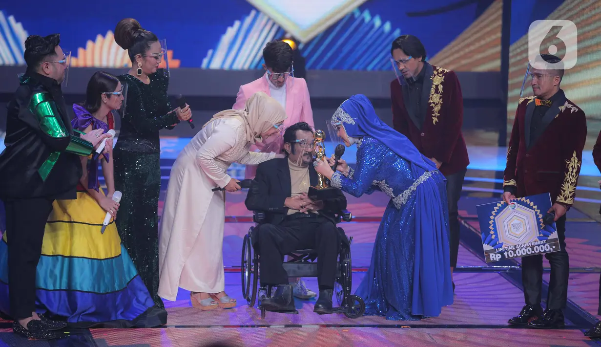 Penyanyi dangdut senior Hamdan ATT mendapatkan penghargaan Lifetime Achievement dalam acara Indonesian Dangdut Awards 2021 di Studio 5 Indosiar, Jakarta, Rabu (1/12/2021). Penghargaan diberikan atas dedikasi Hamdan ATT untuk musik dangdut di tanah air. (Liputan6.com/Faizal Fanani)