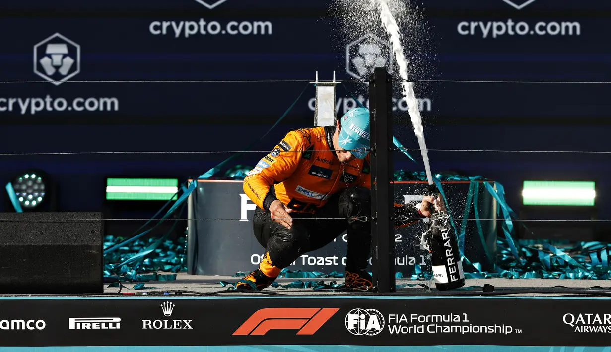 Pembalap Mc Laren, Lando Norris merayakan kemenangan dengan membuka sampanye saat Formula 1 GP Miami 2024 yang berlangsung di Miami International Autodrome, Miami, Florida, Minggu (05/05/2024). (AFP/Chris Graythen)