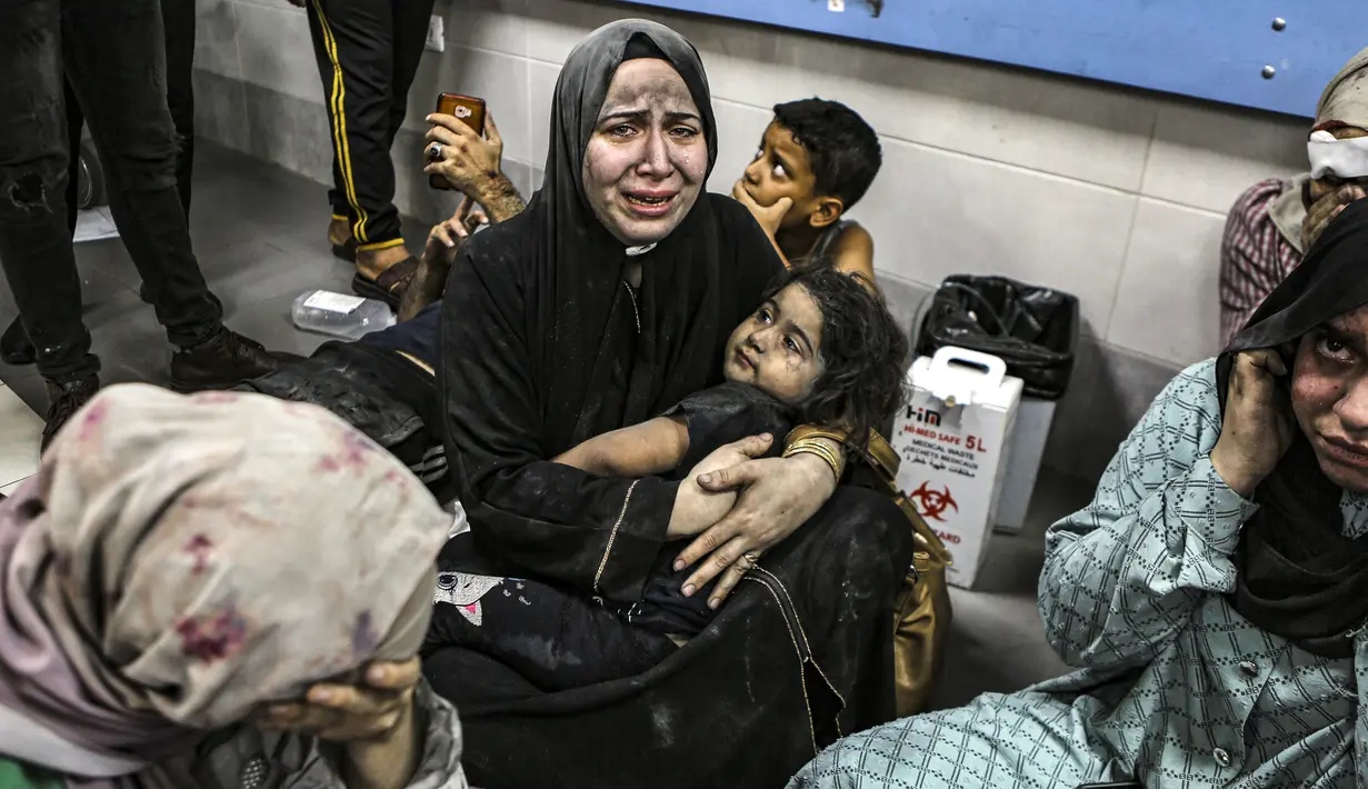 Warga Palestina yang terluka duduk di Rumah Sakit Shifa di Kota Gaza, Jalur Gaza tengah, setelah tiba dari Rumah Sakit al-Ahli menyusul ledakan di sana, Selasa, 17 Oktober 2023. (AP Photo/Abed Khaled)