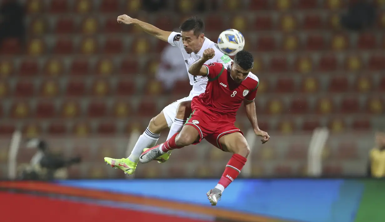 Bek Jepang, Yuto Nagatomo berebut bola udara dengan pemain Oman, Zahir Al Aghbari pada pertandingan kualifikasi Piala Dunia FIFA Qatar 2022 di Sultan Qaboos Sports Complex, Muscat, Oman, Rabu (17/11/2021). Jepang menang tipis atas Oman 1-0. (AP Photo/Kamran Jebreili)