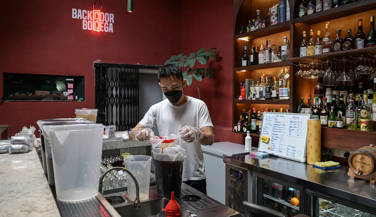 Seorang karyawan menyiapkan minuman ExtraGineca, minuman yang terinspirasi oleh vaksin virus corona Covid-19, di sebuah bar koktail di George Town di pulau Penang, Malaysia (8/9/2021). (AFP/Mohd Rasfan)