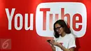 Seorang wanita melintas di depan backdrop YouTube dalam acara yang diselenggarakan YouTube, Jakarta, Selasa (20/10/2015). Menurut Google Indonesia jumlah video yang diunggah pengguna YouTube Indonesia meningkat hingga 600% (Liputan6.com/Immanuel Anton)