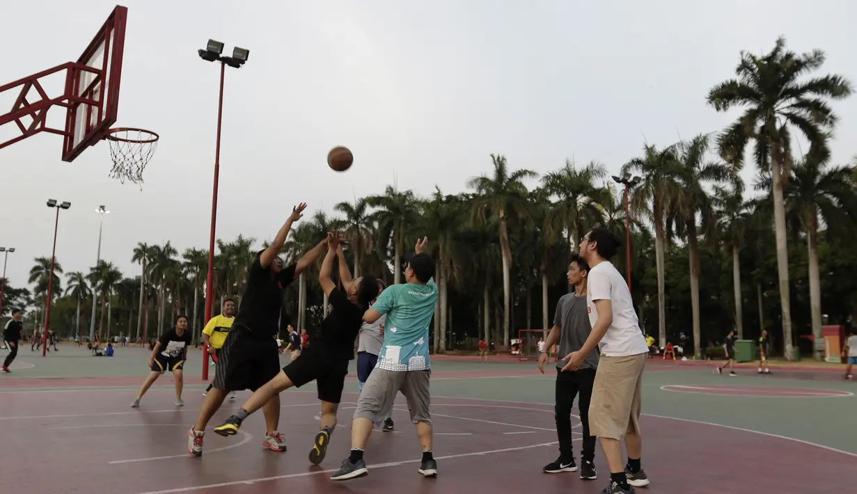 Sejumlah warga bermain basket di kawasan Monas, Jakarta, Jumat (11/10). Kawasan Monas menjadi pilihan warga Jakarta dan pekerja ibu kota untuk berolahraga sore. (Bola.com/Yoppy Renato)