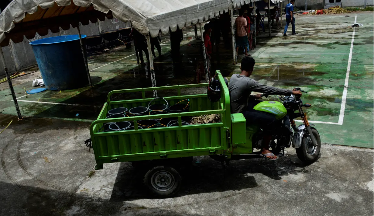 Seorang pria mengangkut makanan kari tradisional untuk disajikan kepada orang-orang selama bulan suci Ramadhan di Banda Aceh (25/4/2021). (AFP/Chaideer Mahyuddin)