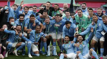 Para pemain Manchester City berpose dengan trofi merayakan kemenangan atas Tottenham Hotspur pada pertandingan final Piala Liga Inggris di stadion Wembley di London, Senin (26/4/2021). City menang tipis atas Tottenham dengan skor 1-0. (AP Photo/Alastair Grant)