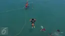 Aksi seorang anak ketika melompat ke laut untuk memburu koin yang dilemparkan penumpang dari atas kapal di Pelabuhan Merak, Banten, Jumat (26/8). Aksi itu menjadi hiburan bagi penumpang yang akan menyeberang ke Pulau Sumatera. (Liputan6.com/Angga Yuniar)
