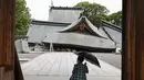 Seorang pengunjung melihat atap-atap yang runtuh dari Kuil Yatsuhiro, sehari setelah gempa bumi di Yatsushiro, prefektur Kumamoto, Rabu, 29 Juli 2026. (Juntaro Yokoyama/Kyodo News via AP)