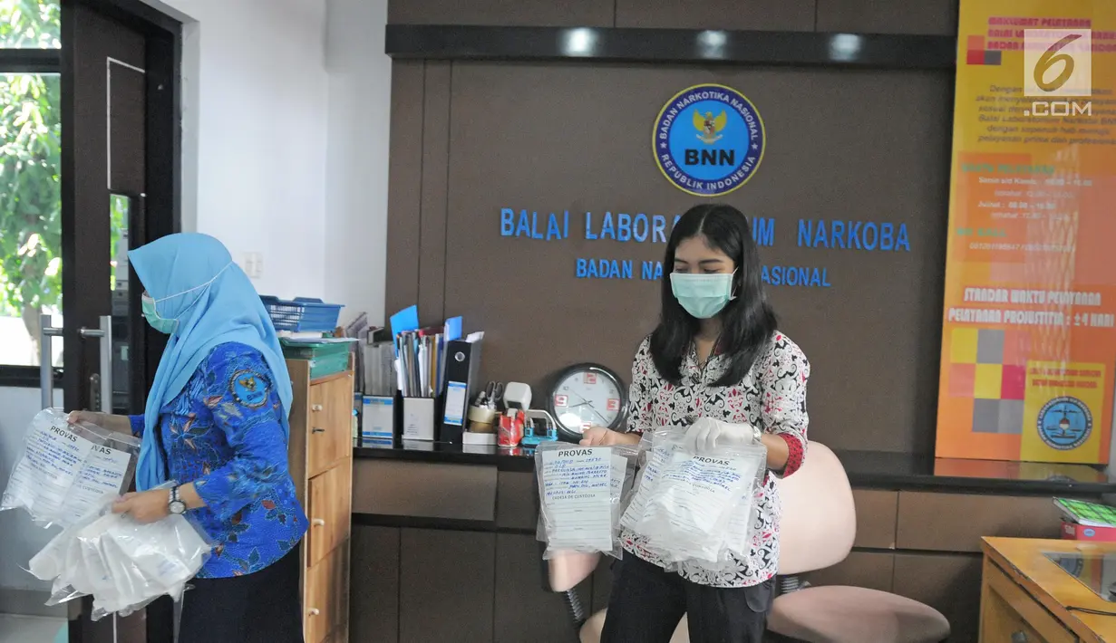 Petugas Laboratorium Narkotik BNN membawa sampel prekursor untuk diperiksa di Laboratorium Narkotik BNN di Jakarta, Jumat (9/2). (Liputan6.com/Herman Zakharia)