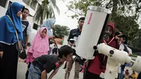 Pengunjung mengamati gerhana matahari cincin menggunakan teleskop di Planetarium Taman Ismail Marzuki, Jakarta, Kamis (26/12/2019). Planetarium menyediakan sekitar 10 teleskop dan kacamata khusus agar pengunjung bisa menyaksikan gerhana matahari cincin dengan aman. (Liputan6.com/Faizal Fanani)