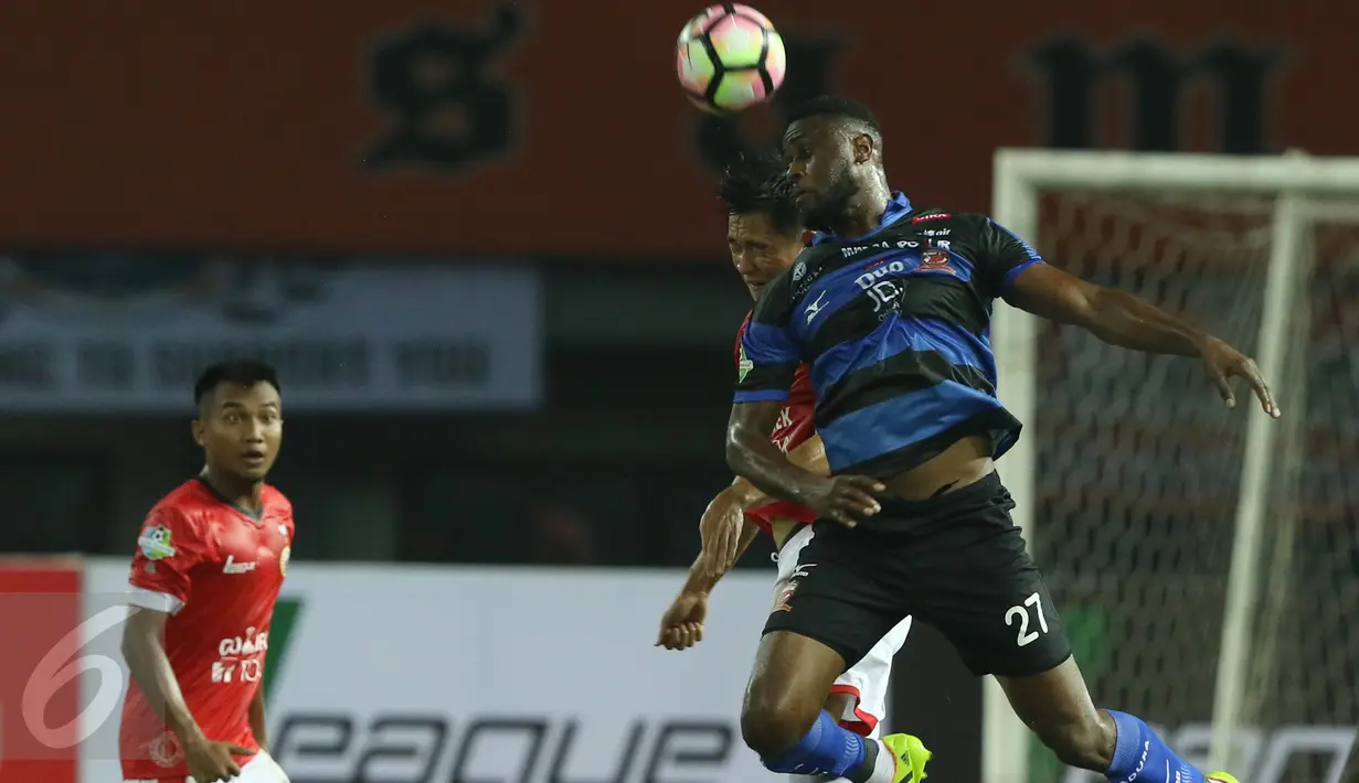 Penyerang Madura United, Boubacar Sanogo (kanan) berebut bola atas dengan pemain Persija saat laga lanjutan Liga 1 di Stadion Patriot Candrabhaga, Bekasi, Kamis (4/5). Persija kalah 0-1 dari Madura United. (Liputan6.com/Helmi Fithriansyah)