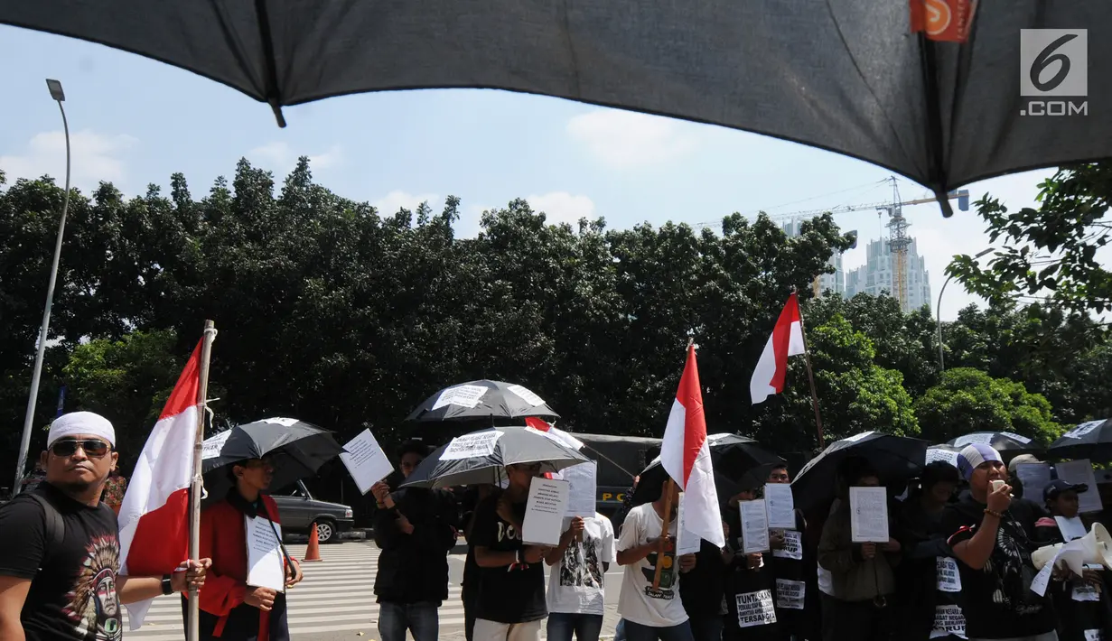 Aktivis dari Gema Tapteng membawa payung hitam saat melakukan aksi unjuk rasa di depan gedung KPK, Jakarta (9/5). Bakhtiar Ahmad Sibarani dinilai telah memberi suap terhadap mantan Ketua MK, M Akil Mochtar. (Merdeka.com/Dwi Narwoko)