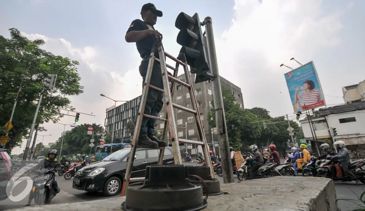 Petugas Dinas Perhubungan DKI Jakarta menganti lampu lalu lintas di kawasan Manggarai, Jakarta, Selasa (19/7). Untuk mencegah kemacetan akibat trafic light, Dishub ganti lampu lalin yang bermasalah. (Liputan6.com/Yoppy Renato)