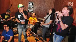 Ahmad Albar dan musisi lainnya seperti Iis 'Rodinda' (vokal), Marcell Siahaan (drum), dan Utox (gitar) saat latihan singel berjudul "Indonesia Bersatu" di Nu Straight Studio Cipete, Jakarta, Selasa (14/11).  (Liputan6.com/Helmi Afandi)
