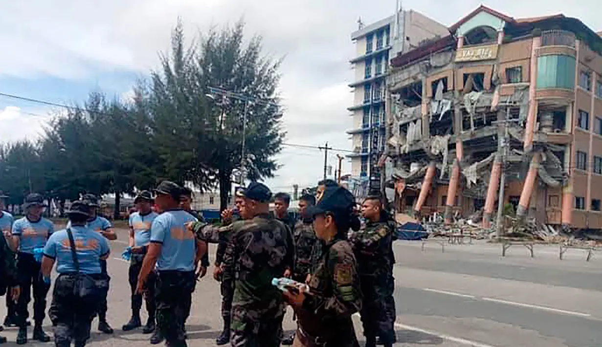 Polisi mengamankan area dekat Hotel Eva yang rusak usai gempa bumi kuat di Kidapawan, provinsi Cotabato utara, Kamis (31/10/2019). Gempa bumi kembali mengguncang Filipina selatan, kali ini bermagnitudo 6,5 dan merupakan gempa kuat ketiga yang berpotensi menimbulkan kerusakan. (AP/Williamor Magbanua)