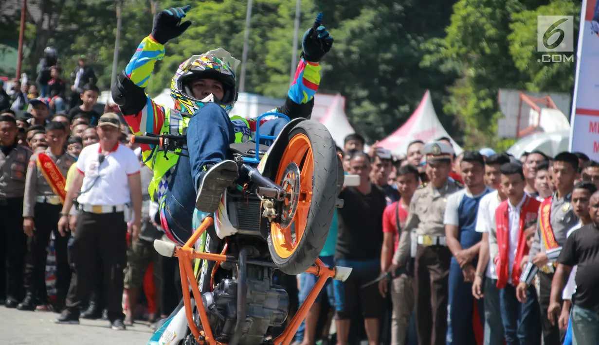 Aksi freestyle motor saat menghibur warga selama kegiatan Millenial Road Safety Festival Gorontalo, Minggu (10/2). Atraksi freestyle tesebut untuk memeriahkan acara Millenial Road Safety Festival . (Liputan6.com/Rahmad Arfandi Ibrahim)