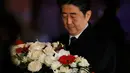 PM Jepang Shinzo Abe membawa karangan bunga tanda bela sungkawa di salah satu lokasi serangan berdarah Paris di gedung konser Bataclan, Prancis, Minggu (30/11). (REUTERS/Gonzalo Fuentes)
