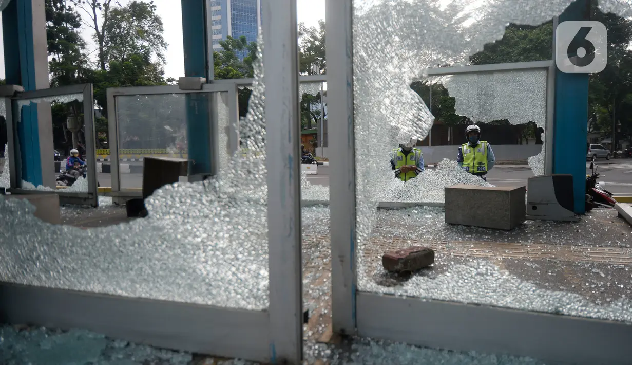 Petugas mengamati kondisi halte transjakarta yang dirusak oleh massa perusuh di Kawasan Bundaran HI Jakarta, Jumat (9/10/2020). Demo menolak omnibus law Undang-Undang (UU) Cipta Kerja diwarnai kericuhan dan pembakaran terhadap sejumlah halte Transjakarta. (merdeka.com/Dwi Narwoko)