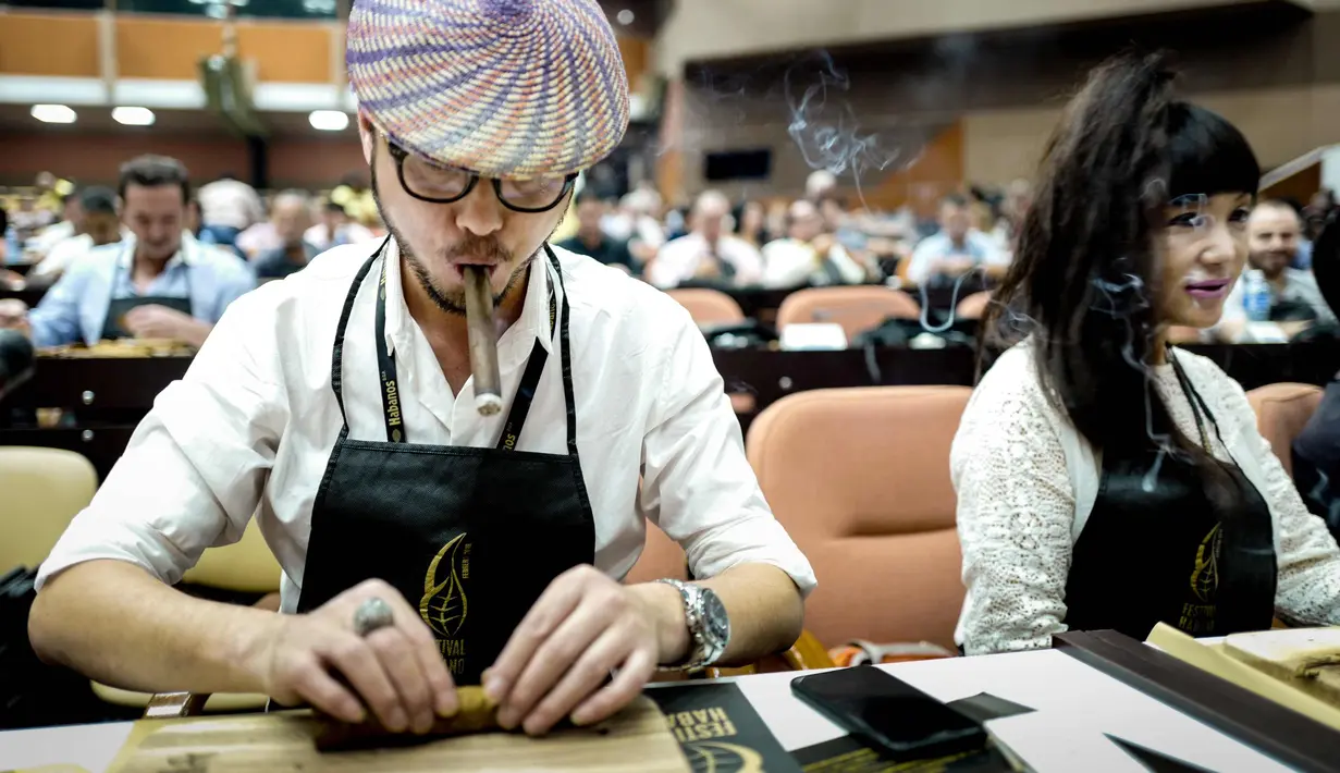 Seorang peserta menggulung cerutu selama kelas master dalam Festival Havana Cigar ke-20 di Istana Konvensi di Havana, Kuba (28/2). (AFP Photo/Adalberto Roque)