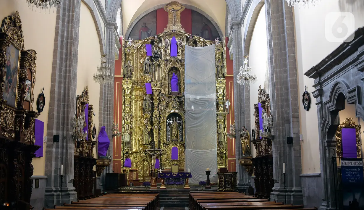 Patung perempuan ditutupi dengan kain ungu di Gereja De los Santos Cosme y Damian di Mexico City, pada Rabu (4/3/2020). Penutupan patung tersebut sebagai bentuk protes terhadap kekerasan gender. (Photo by Pedro PARDO / AFP)