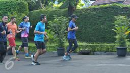 Calon wakil gubernur nomor urut 3, Sandiaga Uno lari ditemani anggota komunitas Jakarta Berlari dan para relawan mengelilingi tempat pemungutan suara (TPS) di sekitar rumahnya di Selong, Kebayoran Baru, Jakarta, Rabu (19/4). (Liputan6.com/Helmi Afandi)