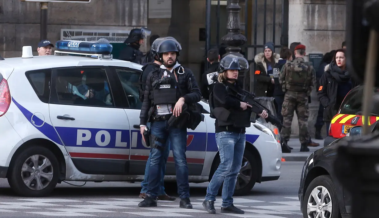 Petugas berjaga-jaga di sekitar Museum Louvre, Perancis, Jumat (3/2). Seorang pria dilaporkan berupaya menyerang seorang tentara Prancis di dekat galeri seni terkenal di Paris, Le Louvre.(AP Photo/Thibault Camus)