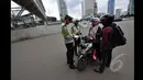 Polisi menghentikan pemotor yang ingin melintasi jalan protokol dari MH Thamrin-Medan Merdeka Barat, Jakarta, Minggu (18/1). (Liputan6.com/Miftahul Hayat) 