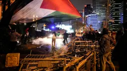 Rekaman video yang beredar di media sosial memperlihatkan sejumlah demonstran melemparkan petasan ke gedung Konsulat Israel di Istanbul, memanjat pagarnya, dan berusaha membuat gedung itu terbakar. (AP Photo/Emrah Gurel)