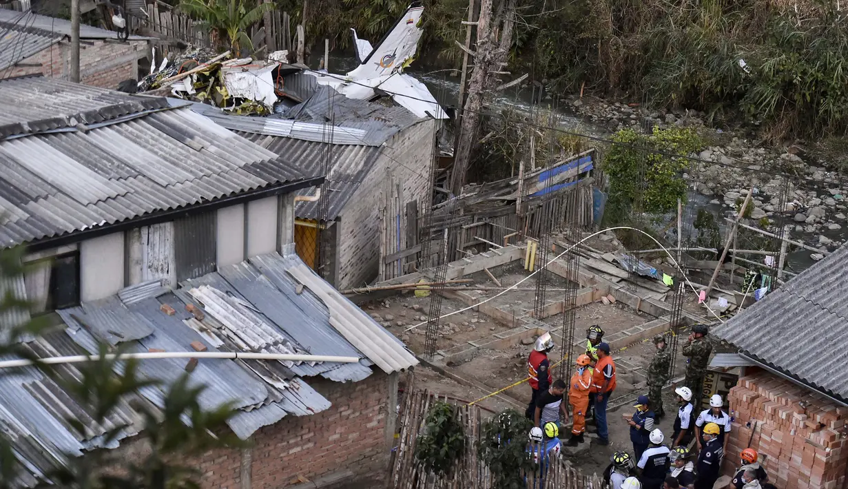 Tim penyelamat berada di lokasi jatuhnya sebuah pesawat kecil di tengah-tengah rumah penduduk di Popayan, Kolombia, Minggu (15/9/2019). Pemadam kebakaran mengatakan tiga orang luka parah, salah satunya adalah seorang anak yang merupakan warga setempat. (Luis ROBAYO / AFP)