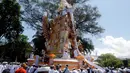 Kerumunan orang menyaksikan arak-arakan menara usungan jenazah Ida Pedanda Nabe Gede Dwija Ngenjung saat upacara Ngaben di Denpasar, Bali, Jumat (8/10/2021). Upacara Ngaben itu sebagai penghormatan terakhir terhadap seorang pemuka agama Hindu di Bali. (AP Photo/Firdia Lisnawati)
