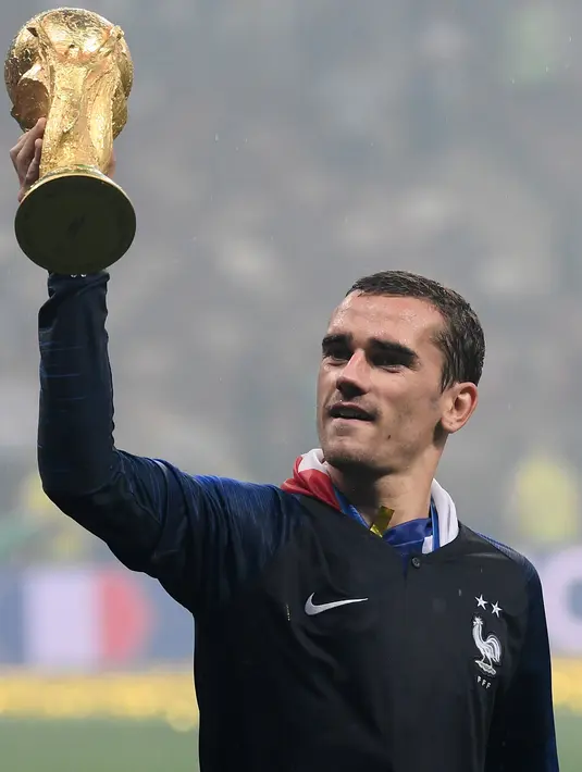 Penyerang Prancis, Antoine Griezmann mengangkat trofi Piala Dunia FIFA setelah pertandingan final Piala Dunia 2018 antara Prancis dan Kroasia di Stadion Luzhniki di Moskow (15/7/2018). Antoine Griezmann telah menjalani lima musim bersama klub Atletico Madrid. (AFP Photo/Jewel Samad)