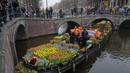 Orang-orang menunggu di jembatan untuk mendapatkan karangan bunga tulip gratis di Amsterdam, Belanda, Sabtu (15/1/2022). Toko-toko di seluruh Belanda dengan hati-hati dibuka kembali setelah berminggu-minggu penguncian virus corona. (AP Photo/Peter Dejong)