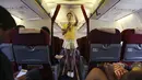 Salah satu pramugari yang mengenakan kostum Timnas Brasil sedang mempraktikan cara menggunakan alat pengaman kepada penumpang dalam penerbangan Kunming ke Hangzhou, Yunnan, China, Senin (23/6/14). (REUTERS/Wong Campion)