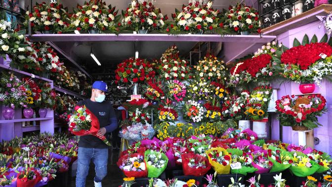 Seorang pekerja membawa karangan bunga di distrik bunga dua hari sebelum Hari Valentine di tengah pandemi COVID-19 di Los Angeles, California (12/2/2021).  Jumlah kematian akibat virus corona di AS lebih dari 450.000.  (Mario Tama/Getty Images/AFP)