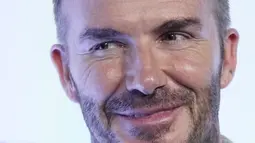 David Beckham tersenyum saat berpose untuk fotografer dalam acara Qatar Fashion United di Stadion 974 di Doha, Qatar, Jumat, 16 Desember 2022.David Beckham tampil trendi dalam balutan sweter berpanel cokelat. (AP Photo/Pavel Golovkin)