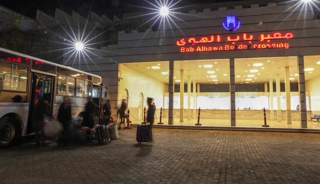 Pengungsi Suriah yang tinggal di Turki naik bus melalui penyeberangan perbatasan Bab al-Hawa utara, pada 17 Februari 2023, saat mereka kembali ke Suriah setelah gempa bumi yang mematikan. Turki minggu ini mengizinkan warga Suriah di bawah perlindungannya yang memegang kartu identitas dari salah satu provinsi yang dilanda gempa untuk pergi antara tiga dan enam bulan. (AFP/Omar Haj Kadour)