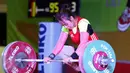 Lifter DKI Jakarta, Irma C Gusdarifah melakukan angkatan clean and jerk kelas 58kg PON XIX Jabar di Gymnasium Si Jalak Harupat, Kab Bandung, Rabu (21/9). Irma meraih perunggu dengan total angkatan 170kg. (Liputan6.com/Helmi Fithriansyah)