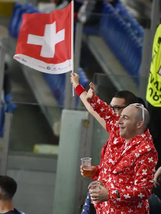 Suporter timnas Swiss mengibarkan bendera di tribun penonton sebelum dimulainya laga Grup A Euro 2020 antara Italia dan Swiss di stadion Olimpiade di Roma, Rabu (16/6/2021). Dalam laga tersebut, Timnas Italia menghajar Swiss dengan skor 3-0. (AP Photo/Riccardo Antimiani, Pool)