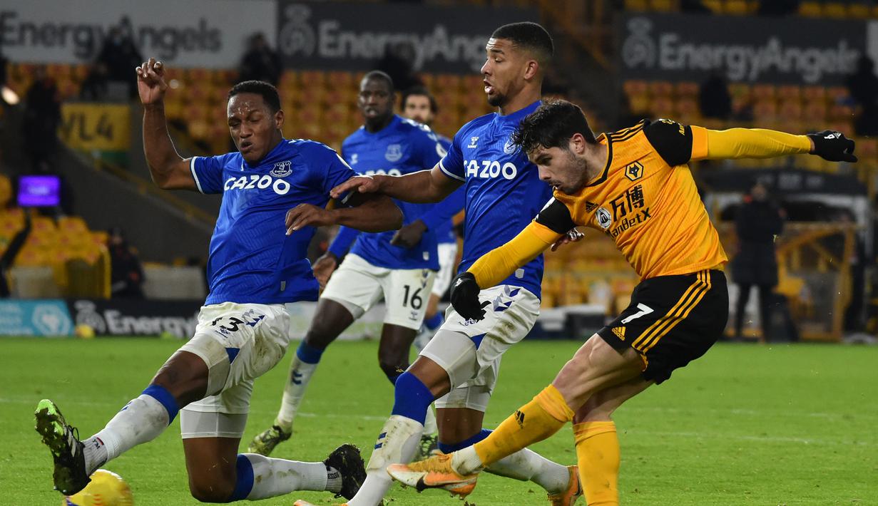 Gelandang Wolverhampton Wanderers, Pedro Neto (kanan) melepaskan tendangan ke gawang Everton dalam laga lanjutan Liga Inggris 2020/21 di Molineux Stadium, Selasa (12/1/2021). Wolverhampton Wanderers kalah 1-2 dari Everton. (AFP/Rui Vieira/Pool)