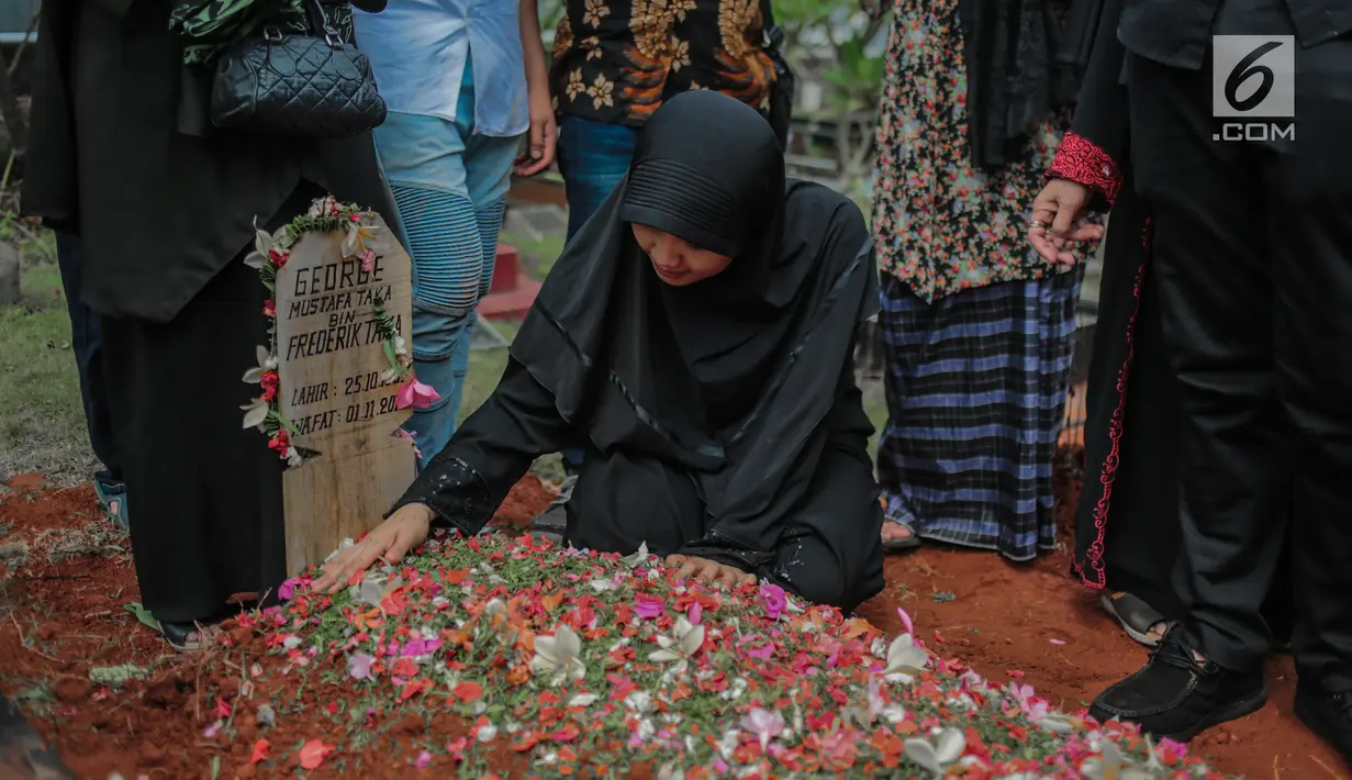 Istri mendiang George Mustafa Taka, Desty Amalia berada di dekat makam suaminya di Komplek Pemakaman Kempo, Jatiwaringin, Pondok Gede, Jakarta, Jumat (2/10). George Mustafa Taka meninggal akibat serangan jantung. (Liputan6.com/Faizal Fanani)