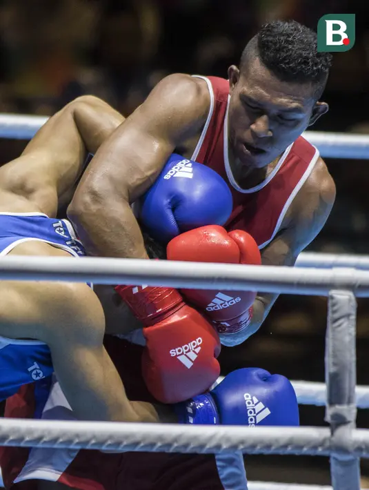 Petinju Indonesia, Brama Betaubun, menahan petinju Taiwan, Chia-Wei Kan, pada Invitation Tournament Asian Games di JiExpo Kemayoran, Jakarta, Senin (12/2/2018). Petinju Indonesia kalah 1-4 dari petinju Taiwan. (Bola.com/Vitalis Yogi Trisna)