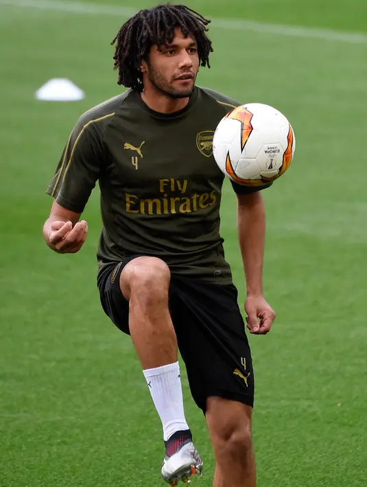 Gelandang Arsenal asal Mesir, Mohamed Elneny mengontrol bola saat latihan tim di stadion Mestalla di Valencia, Spanyol (8/5/2019). Arsenal akan bertanding melawan Valencia pada leg kedua babak semifinal Liga Europa di Mestalla. (AFP Photo/Jose Jordan)