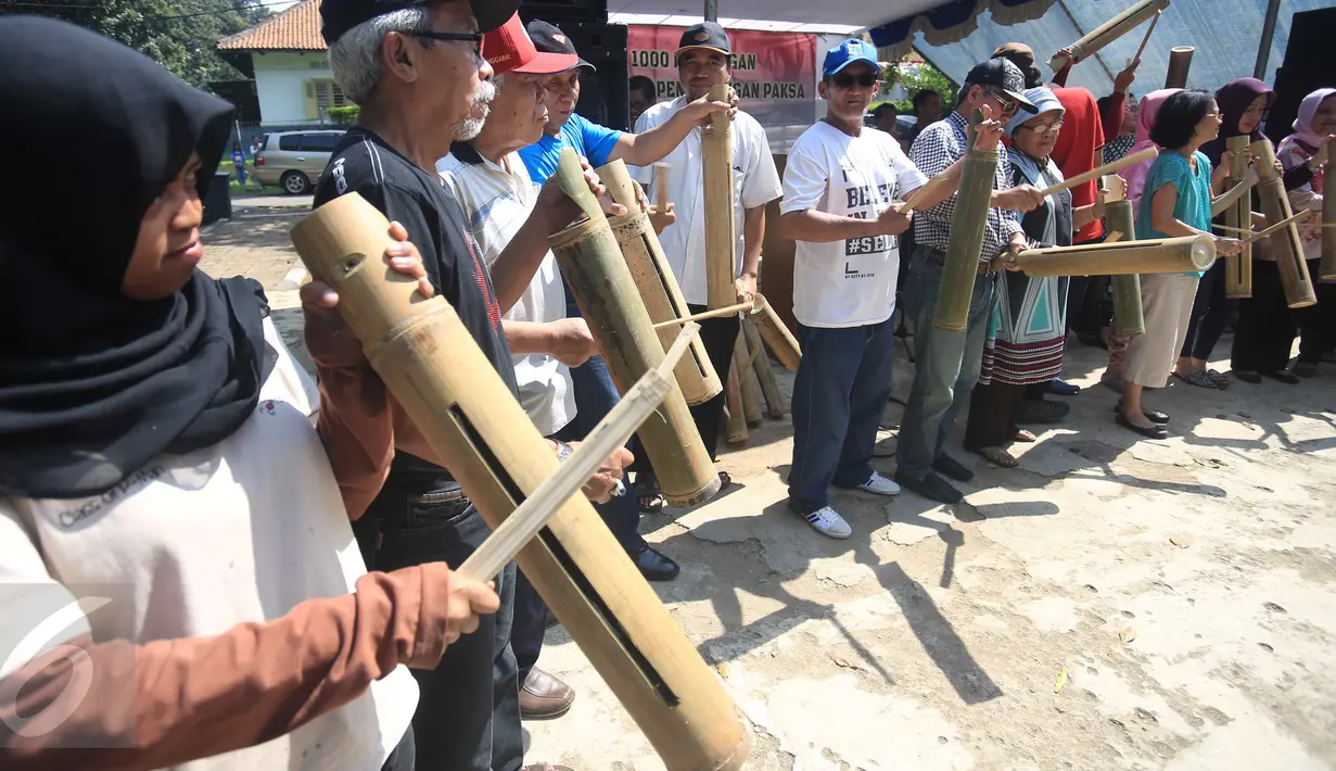 Warga memukul kentongan sebagai protes rencana pengosongan rumah dilakukan oleh PT KAI di Manggarai, Jakarta, Minggu (30/7). Melalui aksi '1000 Kentongan Melawan Pengosongan Paksa', mereka menolak digusur oleh PT KAI. (Liputan6.com/Angga Yuniar)
