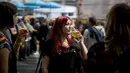 Seorang wanita menikmati minum bir selama The Great British Beer Festival di Kensington Olympia di London barat (6/8/2019). Great British Beer Festival tahunan ini diadakan 6-10 Agustus 2019. (AFP Photo/Tolga Akmen)