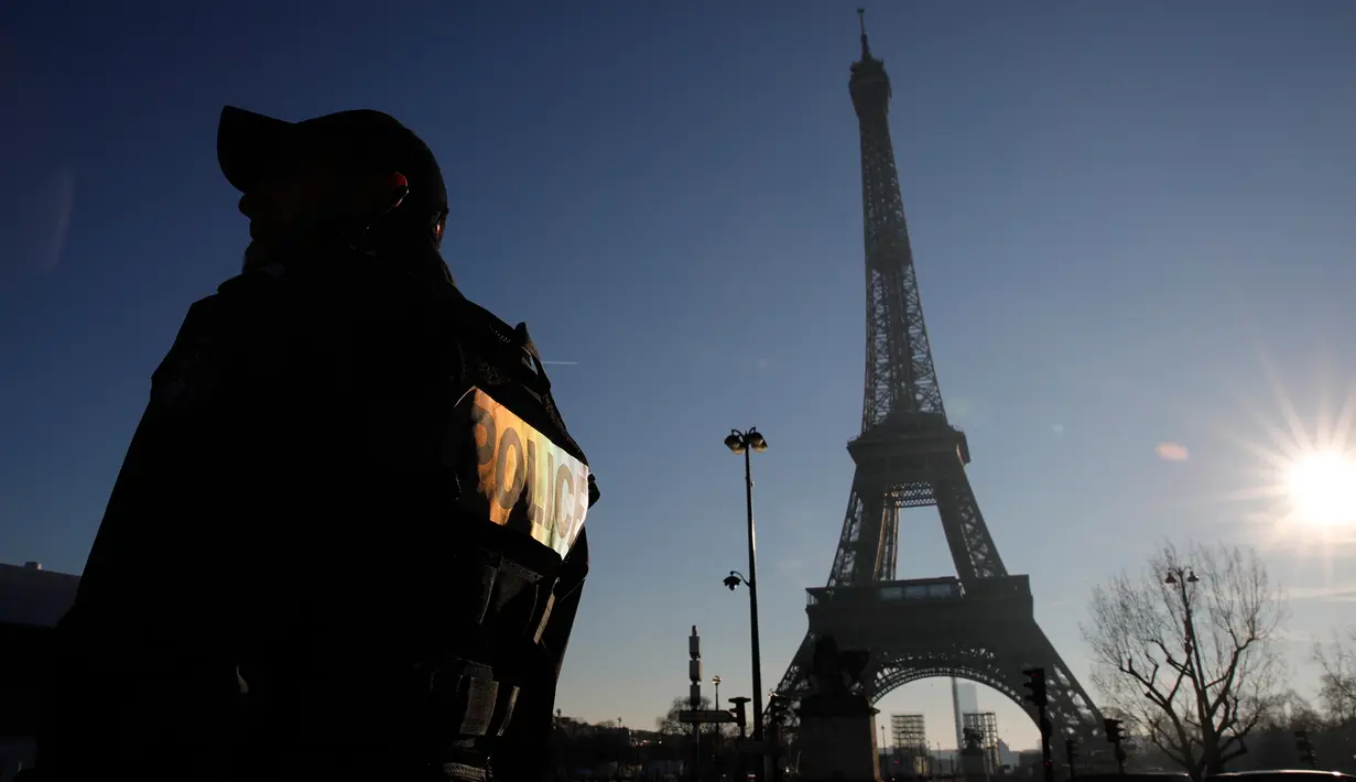 Polisi anti huru-hara berpatroli di dekat Menara Eiffel di Paris,  Senin (30/12/2019). Pemerintah Prancis akan mengerahkan 100.000 petugas polisi untuk mengamankan ruang publik pada perayaan malam Tahun Baru di tengah aksi mogok yang sedang berlangsung. (AP/Christophe Ena)