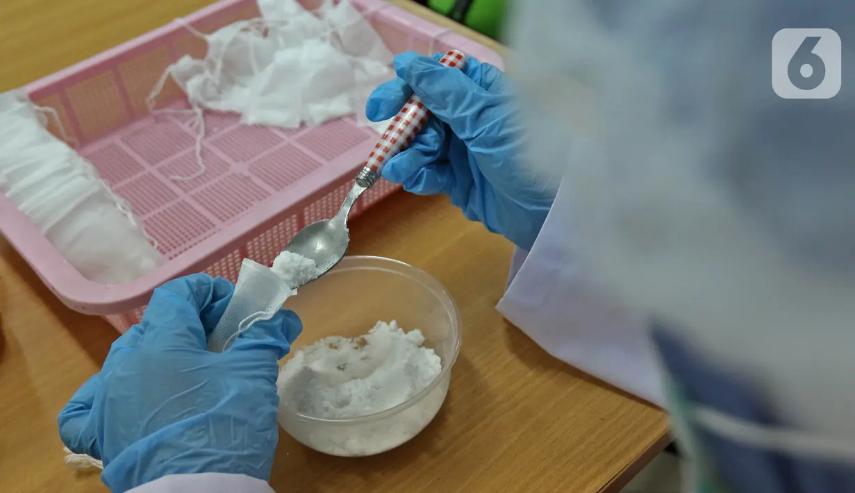 Pekerja lab menaruh serbuk hasil pengolahan laboratorium nano teknologi di balai penelitian dan pengembangan Kementerian Pertanian, Bogor, Jawa Barat, Selasa (7/7/2020). (Liputan6.com/Herman Zakharia)
