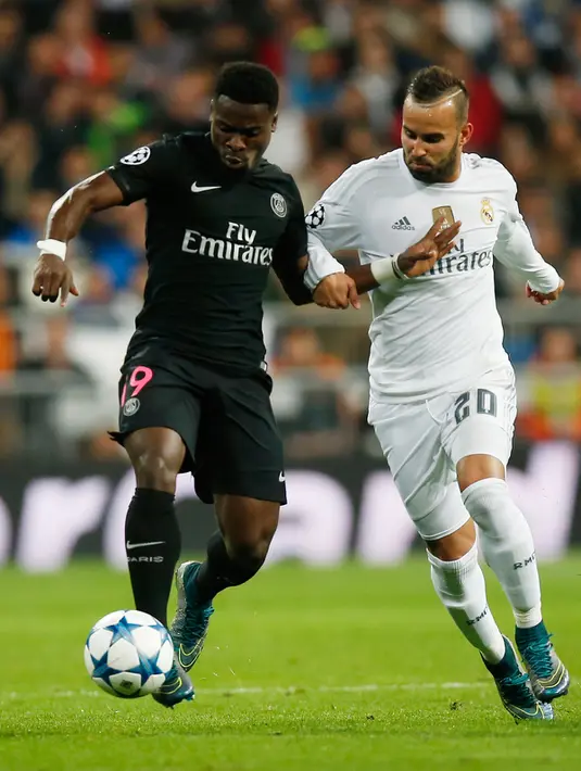 Bek PSG, Serge Aurier berusaha membawa bola dari kejaran penyerang Real Madrid, Jese pada liga champions di stadion Santiago Bernabeu, Madrid, Spanyol (3/11). Real Madrid menang atas PSG dengan skor 1-0. (AFP PHOTO/Sergio Perez)