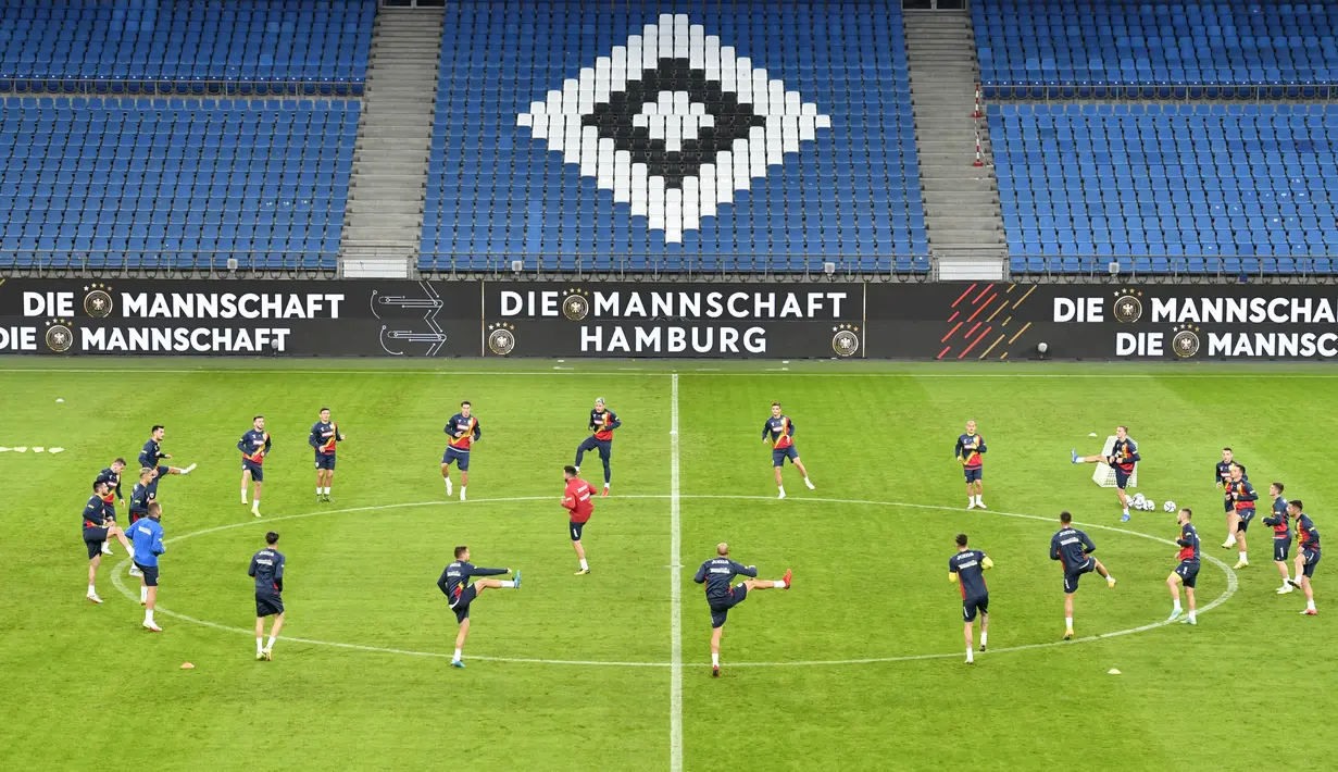 Para pemain timnas Rumania melakukan pemanasan selama sesi latihan di Hamburg, Jerman, Kamis (7/10/2021). Timnas Rumania akan menantang Jerman dalam laga lanjutan Grup J Kualifikasi Piala Dunia 2022 zona Eropa di Volksparkstadion, Sabtu dini hari WIB. (John MACDOUGALL/AFP)