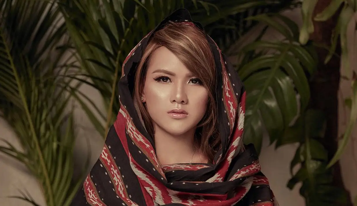 Tak hanya tampil tomboy, kenakan penutup kepala Evelyn nampak luwes dengan kain yang memiliki corak adat (Liputan6.com/IG/evelinnadaanjani)