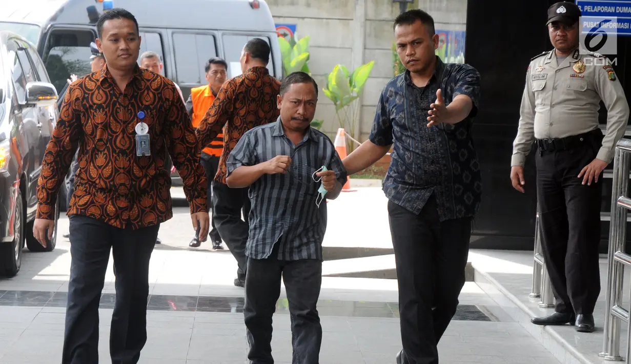 Kader Partai Perindo Kabupaten Bengkulu Selatan, Juhari alias Jukak dikawal petugas tiba di gedung KPK, Jakarta, Rabu (16/5). Jukak terjaring Operasi Tangkap Tangan (OTT) di rumah pribadi Bupati Bengkulu Selatan, Dirwan Mahmud. (Merdeka.com/Dwi Narwoko)