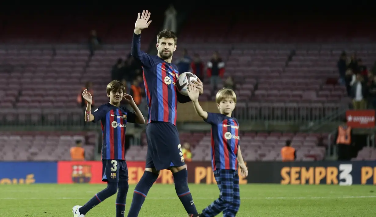 Bek Barcelona, Gerard Pique dan putranya, Milan dan Sasha, melambaikan tangan kepada para pendukung di akhir pertandingan melawan Almeria di stadion Camp Nou di Barcelona, Spanyol, Minggu (6/11/2022). Pique menimba ilmu di akademi La Masia milik Barca sejak masih berusia 10 tahun. (AP Photo/Joan Monfort)